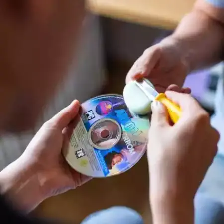 jovenes restaurando un cdrom de un juego clasico con un pulidor de cdrom